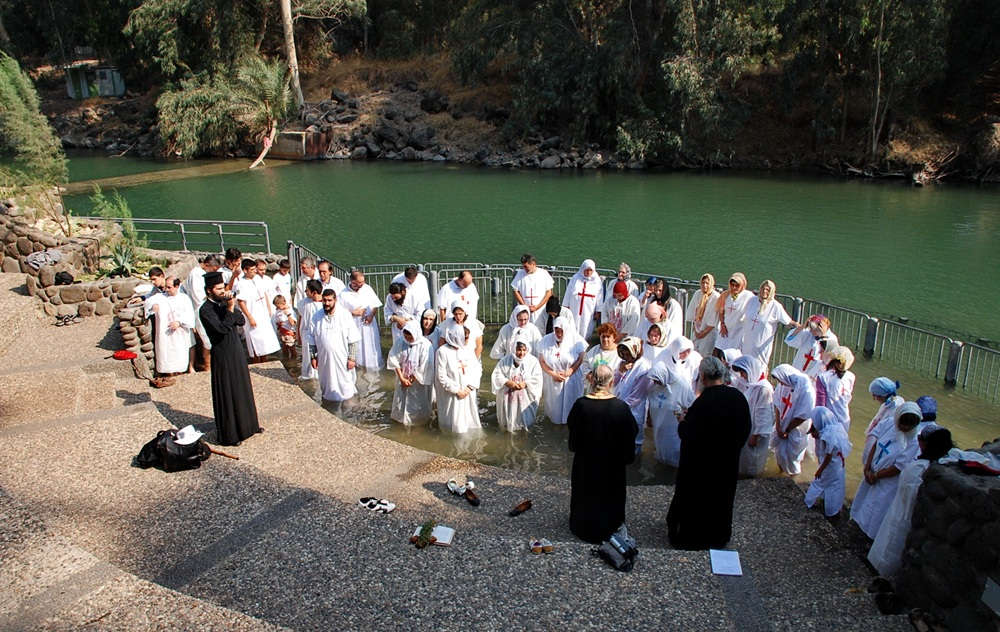 a group of pilgrims during baptism in jordan river